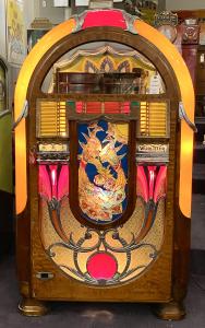 Beautifully restored Wurlitzer 850 Peacock jukebox, playing 24 78 rpm records, in a veneered wooden case, the central panel decorated with an illuminated flashing peacock.