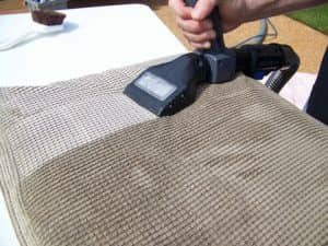 Upholstery cleaning in progress, showing the cleaned side and the side still to be cleaned