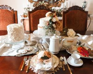 Tablescape with faux cakes and cookies plated and styled on a linen table runner with gold and silver accents