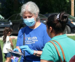 A Youth for Human Rights volunteer shows a mother the human rights educational resources and how she can use them to help her children overcome bullying at school and on social media.
