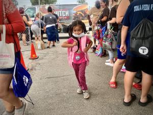 A young student receives a new backpack at the Back-to-School Backpack Event in Bloomington, CA