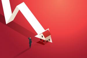 Businessman looks at a graph of the real estate market where the arrowhead is falling