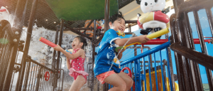 two young kids playing with splash area with water guns