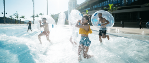 group of people running into wave pool with inner tubes