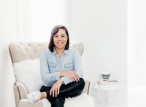 Canadian author Juliana Leamen sitting on her chair smiling