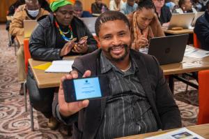 An educator proudly displaying his online certificate after completing one of the courses of the tools for life program
