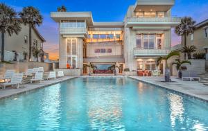489 Ocean Shore Blvd Ormond Beach Florida - William Morgan Design - Reflecting Pool with Cascades: 63-foot three-lane infinity pool is framed by water cascades, bottle palms and private access to the beach. Water flowing from top of the cascades also “off