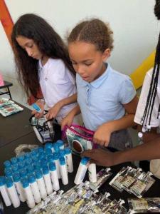 Embrace Girl Foundation students collect personal hygiene products at group giveaway.