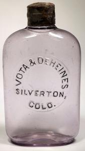 Circa 1898-1908 Vota & DeHeines (Silverton, Colo.) pocket whiskey flask, light purple with black lettering and a ground top with a metal cap, 5 ¾ inches tall ($4,375).