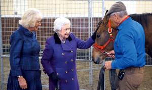 Queen Elizabeth II is shown a horse by renowned trainer Monty Roberts.