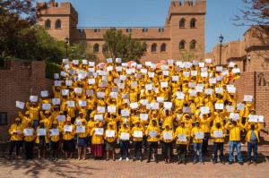 Graduates excitedly pose for a group shot after graduating