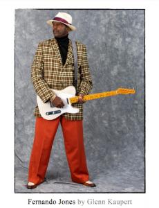 Fernando Jones, an internationally known guitarist, educator and songwriter based in Chicago, is shown in a concert suit with his guitar. He heads the blues group Fernando Jones and My Band! and founded Blues Kids of America, a multicultural, interdiscipl