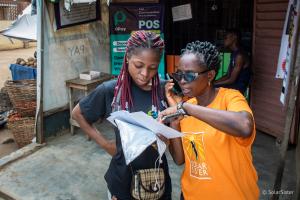 Solar Sister Entrepreneur Oluwatoyin Olugade reviews clean cookstove options with an Envirofit representative in Lagos, Nigeria.