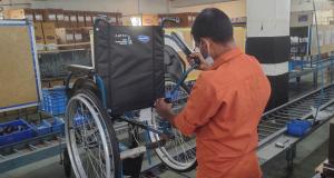 Man adjusting Co-branded Action 1R Invacare and Free Wheelchair Mission Wheelchair