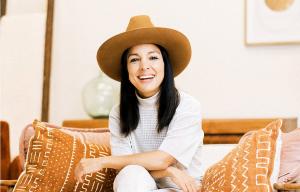 Miki Agrawal, social entrepreneur and best-selling author, sitting on a couch smiling