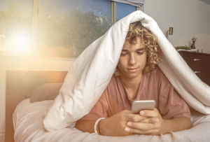 Teenager texting on his cell phone.