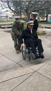 Rear Admiral Kyle Cozad going up stairs in wheelchair.