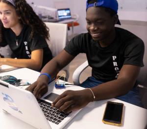 Students at laptop review data analyst course