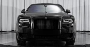 a photo of a black rolls royce Ghost in a showroom.