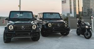 a photo of two black g wagons and a black bike, as part of the company's fleet