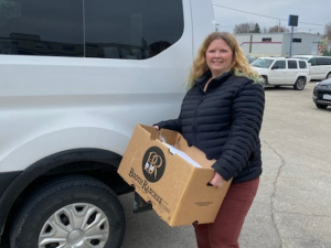Staff from North Iowa Community Action carries box of CACFP food