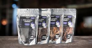 Chicken, beef, pork, and turkey jerky pouches on a wooden table with dark black background