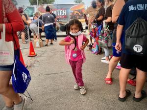 A child at Project Boon's Backpack Event receives a backpack delivered by Hitch Burger