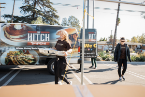 A volunteer prepares to distribute warm Thanksgiving meals delivered by Hitch Burger