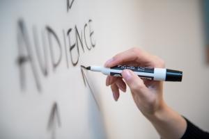 A picture of a person writing ‘audience’ on a whiteboard, Darren and Mike Dream Team help entrepreneurs find their target audience