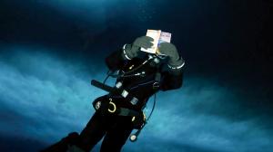 Dr. Thurber reading "Antarctica!" while scuba diving beneath the sea ice.