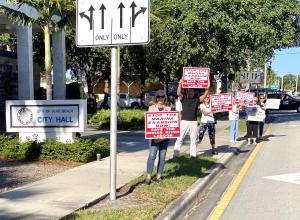 signholders at city hall opposing the marina expansion