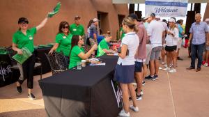 Volunteers greet players and hand out swag bags before The Rosendin Foundation Golf Tournament