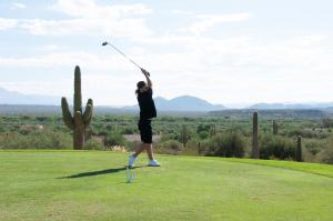 A golfer captured in mid-swing at The Rosendin Foundation golf tournament