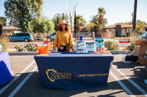 A vendor prepares to distribute information to attendees at Eat & Be Well 2021