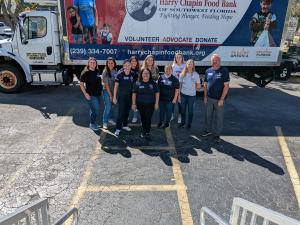10 Midland Trust team members stand in front of a Harry Chapin distribution truck posing for a photo.
