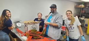4 Midland Trust team members are putting zucchini in bags.