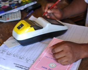 Close-up of a cashier's hands using a POS machine