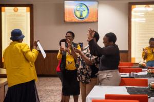 An educator happily showcasing her certificate to other educators after graduating.