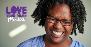 Person smiling with LoveYourBrain Mindset logo to their left