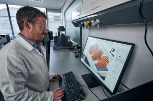 4D Biomaterials scientist in a white coat looking at a computer screen while working on a product development project