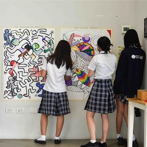 Students and teachers work on murals