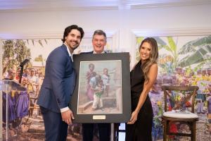 Wells of Life Founder, Nick Jordan, presents Humanitarian of the Year Award recipients, Austin & Maggie Hedges with an art piece from local artist Toni Danchik as a gift for donating the 1000th well.