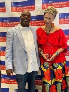 HIFF Executive Director Jacquil Constant presents the 2022 HIFF Diaspora Award to Marguerite Erasme Lathan. She serves on the Board of Directors for Fonkoze, an organization that provides financial and other services to empower Haitians -primarily women.