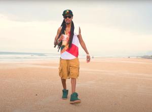 Main artist Dez Nado from Flawda Ish song on beach in Florida flag tank top