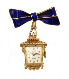 Rolex 18kt gold lantern charm manual watch, circa 1950s-1960s, together with an 18kt and blue enamel bow form pin with clasp (est. $4,000-6,000).
