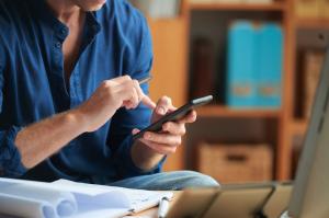 Person uses mobile phone to interact with customers.