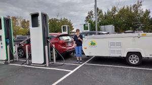 Gail Thorpe gives a thumbs up while charging the EV on the trip