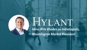 Headshot of man, Rick Rhodes, on background image of people walking through a building. Text overlay, to the right of Rick's headshot: "Hylant Hires Rick Rhodes as Indianapolis, Bloomington Market President."