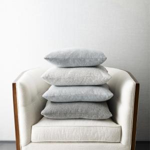 A chair and throw pillows covered in the new fabric for wellness by Crypton and Kravet.