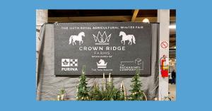 An image of a black and white foam sign, depicting the logos of Crown Ridge Farms and its sponsors, hanging on the outside wall of a horse stall.